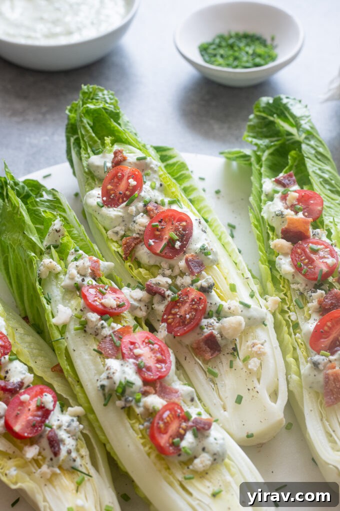 Close-up of a Romaine Wedge Salad drizzled with creamy Green Goddess dressing on a platter, highlighting the fresh ingredients.
