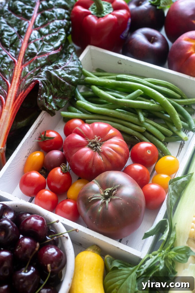 August seasonal produce including tomatoes, green beans, stone fruit and more, laid out beautifully.