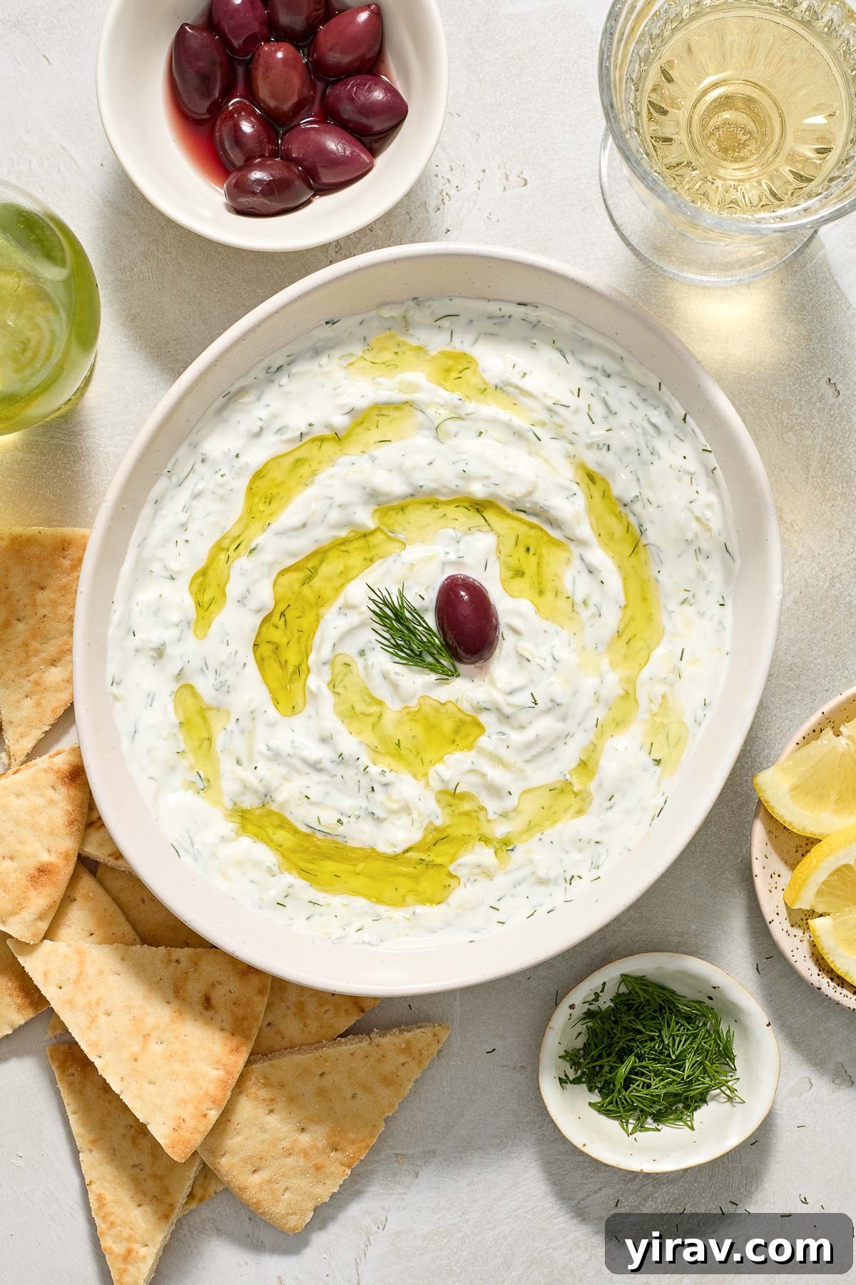 Greek tzatziki in a bowl with olive oil and dill.