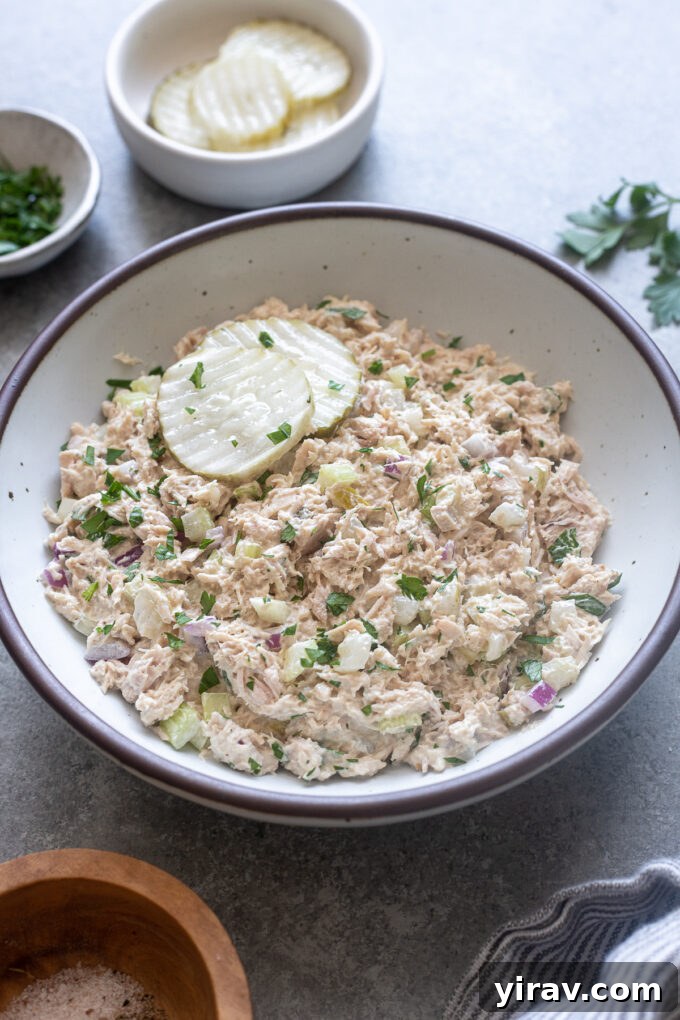 Zesty Dill Pickle Tuna 3 Dill pickle tuna salad garnished with two pickle chips and a sprig of parsley, ready for serving.