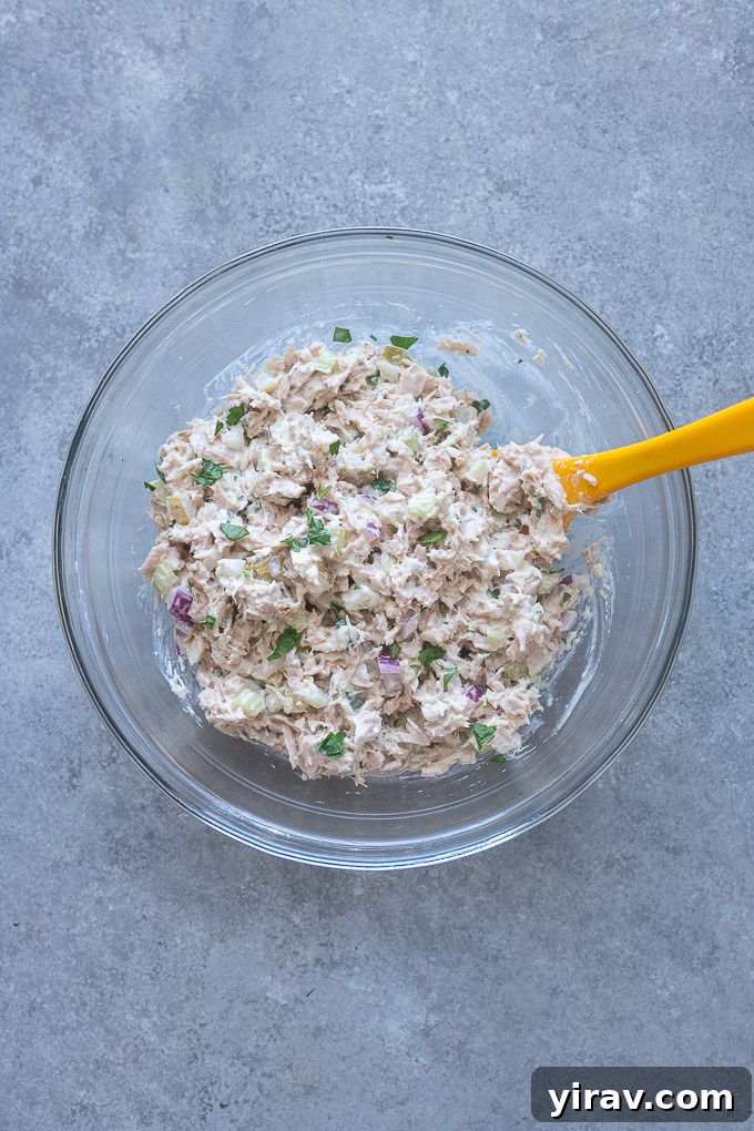 Zesty Dill Pickle Tuna 6 All ingredients for dill pickle tuna salad, including mayo, mustard, pickles, and vegetables, combined in a mixing bowl.