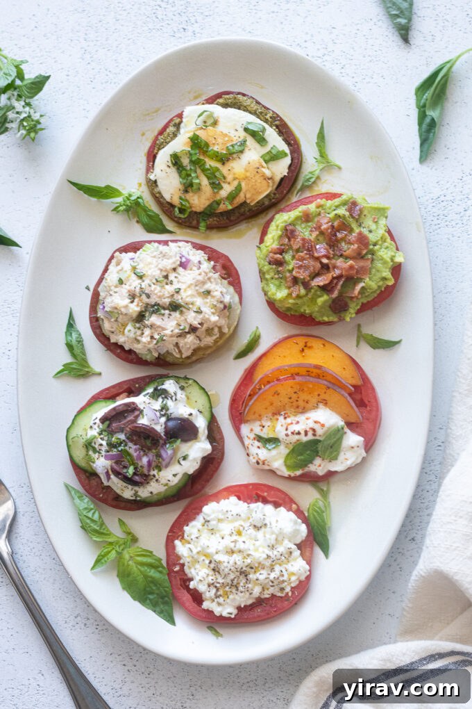 Heirloom tomato flight on a white platter with fresh basil garnishes.