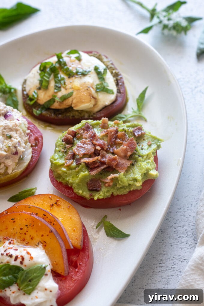 Heirloom tomato slice with mashed avocado and crumbled bacon topping, resembling avocado toast.