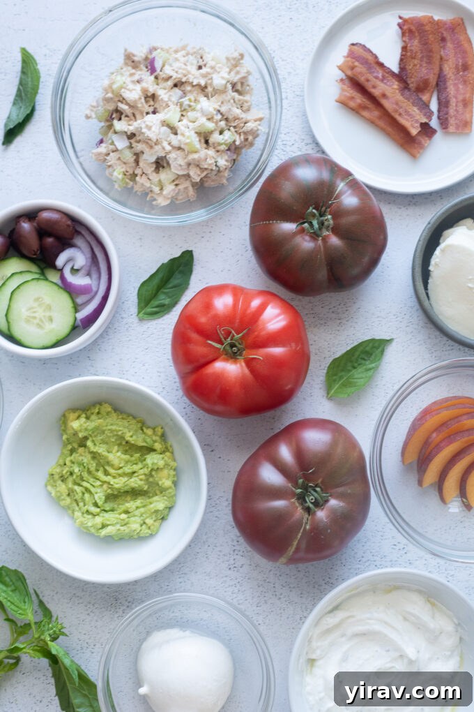 A vibrant assortment of ingredients and toppings for an Heirloom Tomato Flight laid out on a table.