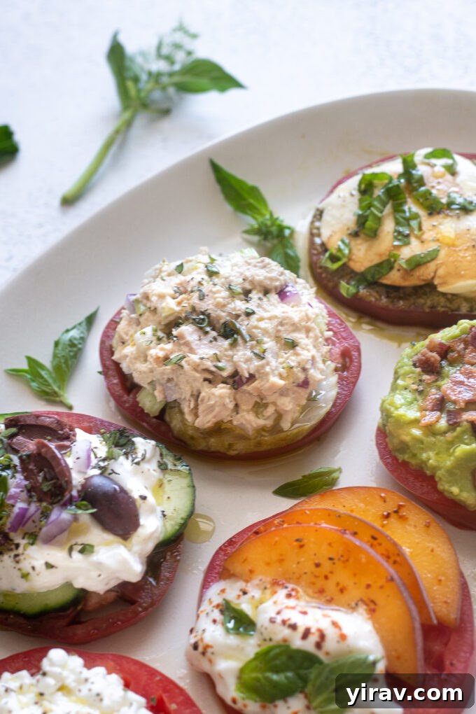 Heirloom tomato slice with a topping of tuna salad and dill pickle chips.