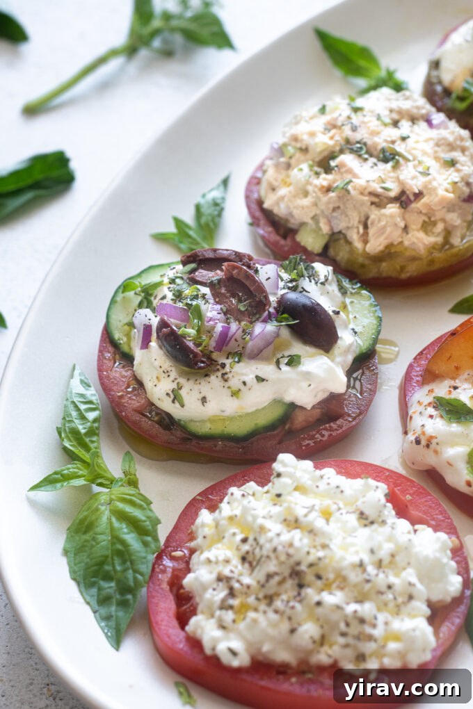 Heirloom tomato slice featuring a Greek-inspired topping with cucumber, tzatziki, olives, and red onion.