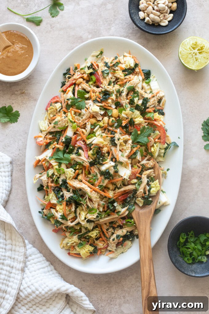 Thai chicken salad on a platter with salad servers.