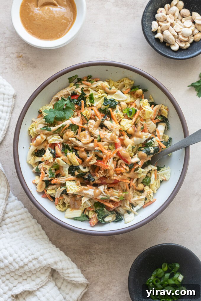 Thai chicken salad with peanut dressing in a bowl with fork.