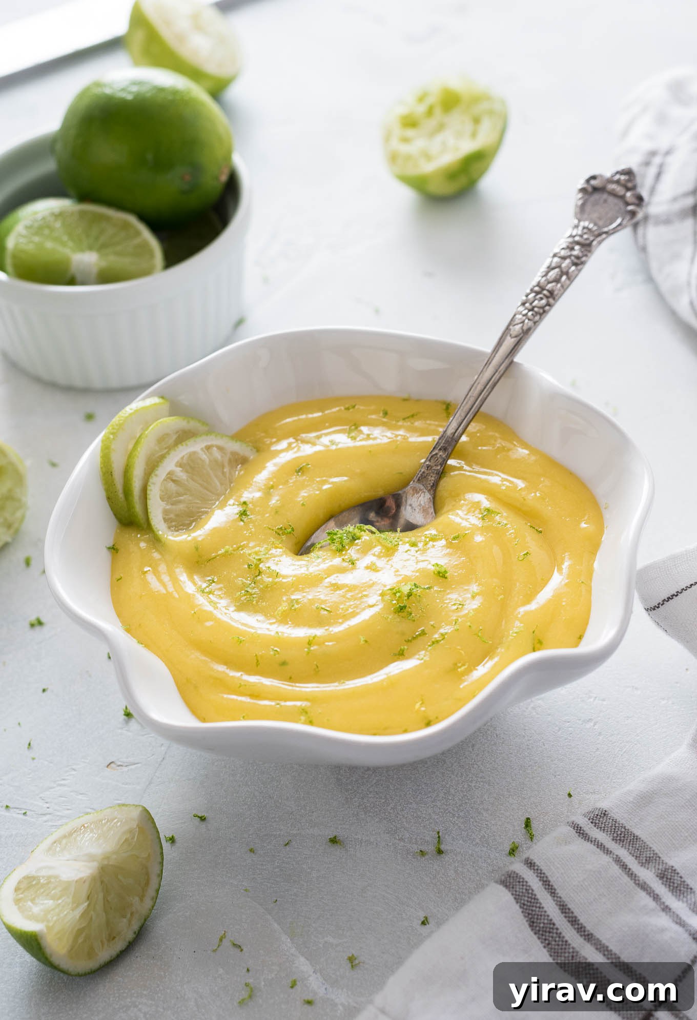 Bowl of lime curd with spoon buried in the middle