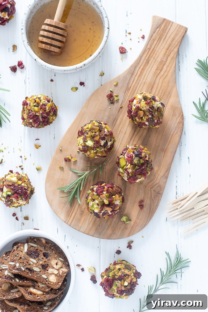 Mini cheese balls on a cutting board with honey and crackers, ready to serve