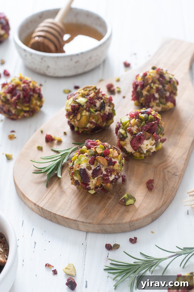 A close-up of mini cheese balls rolled in cranberries and pistachios, ready for a party