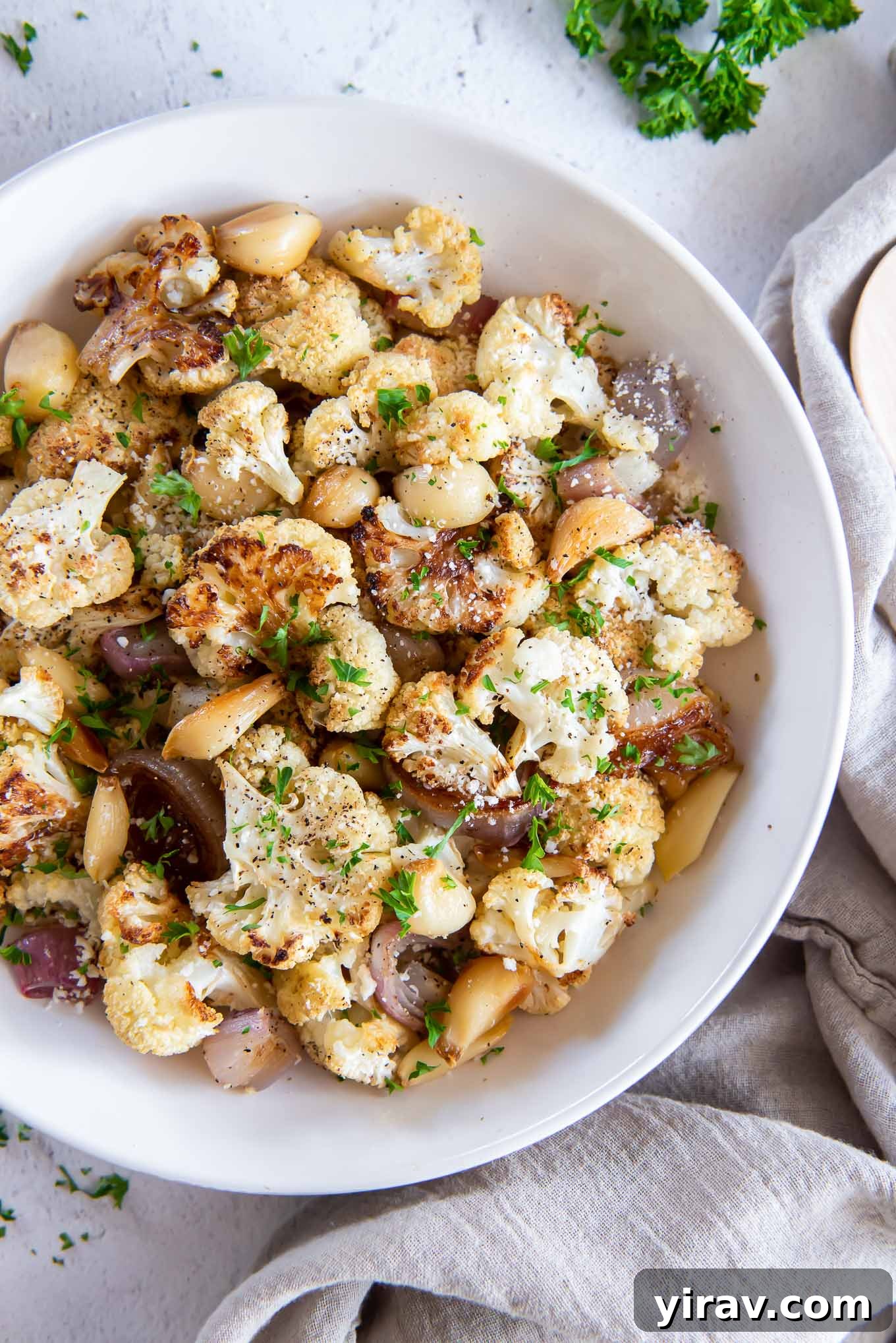 Roasted cauliflower florets served in a white bowl.
