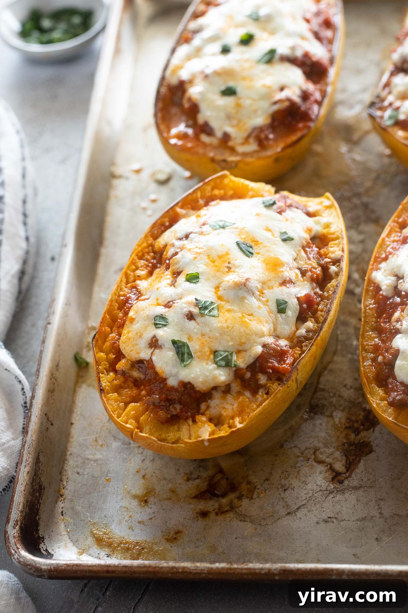 Spaghetti squash lasagna baking on a sheet pan, golden and cheesy.