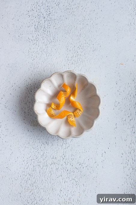 Hold the peel over the cocktail and twist it tightly to express the citrus oils. 