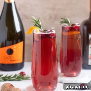 Poinsettia Cocktails garnished with cranberries and orange twist.