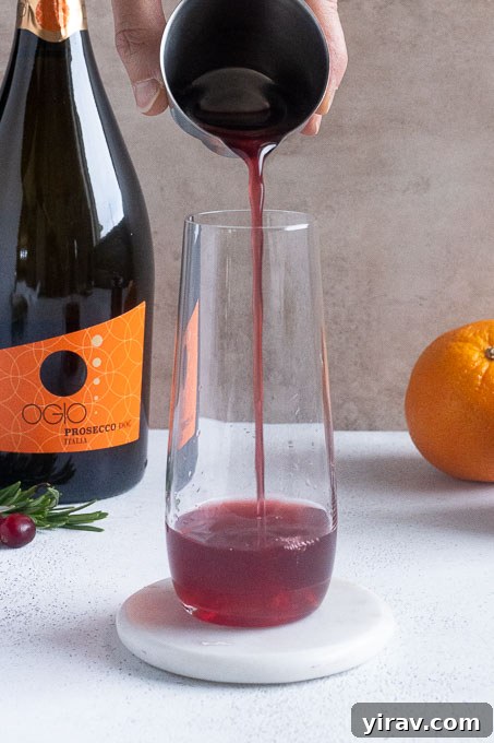 Add cranberry juice and cointreau to a chilled champagne glass.