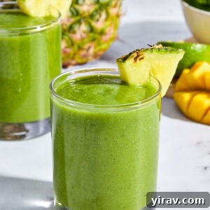 Tropical Green Power Smoothie 8 A vibrant green tropical mango kale smoothie in a tall glass.