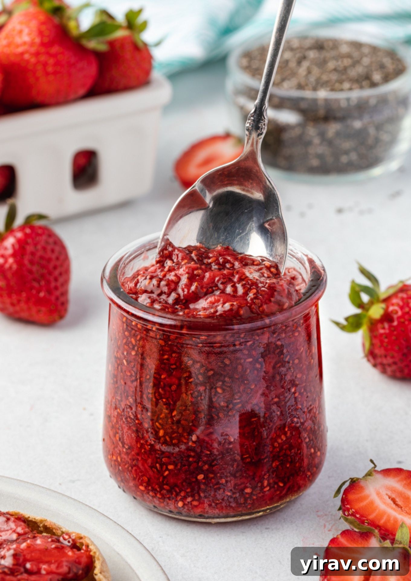 Spoon digging into jar of strawberry chia jam