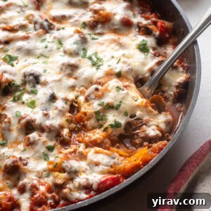 Spaghetti squash casserole in skillet with serving spoon digging in.