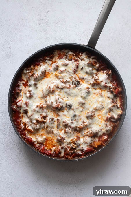 Spaghetti squash casserole in skillet after baking, golden and bubbly.