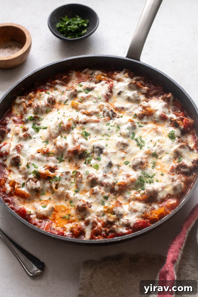 Spaghetti squash casserole with ground beef and cheese in a skillet, showcasing a perfect serve.