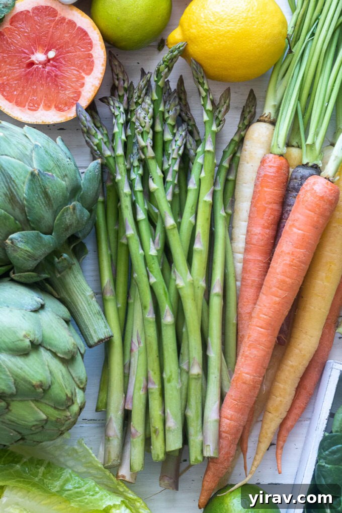 Fresh asparagus spears next to other vegetables, demonstrating how to choose and store various other common vegetables.