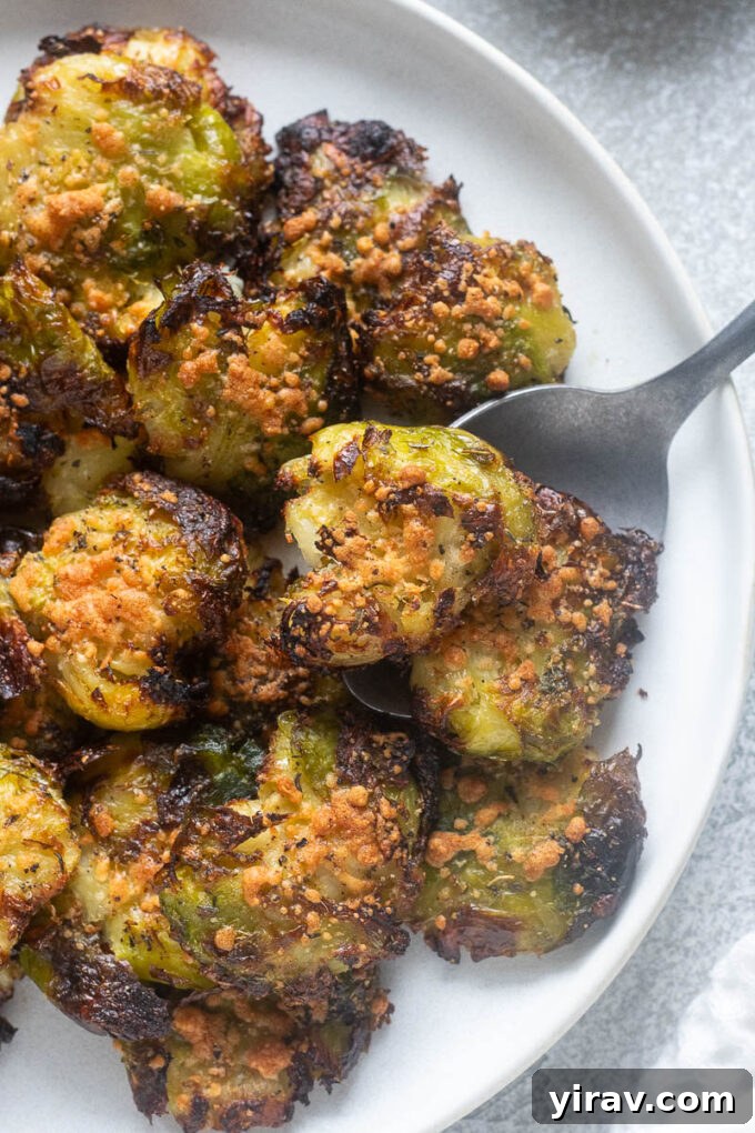 Smashed brussels sprouts with parmesan cheese on a plate.