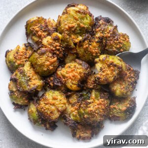Smashed brussels sprouts on a plate with a serving spoon.