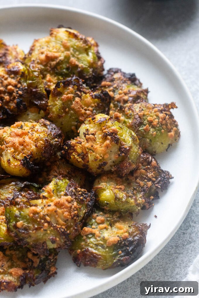Close up of smashed brussels sprouts with parmesan on a plate.