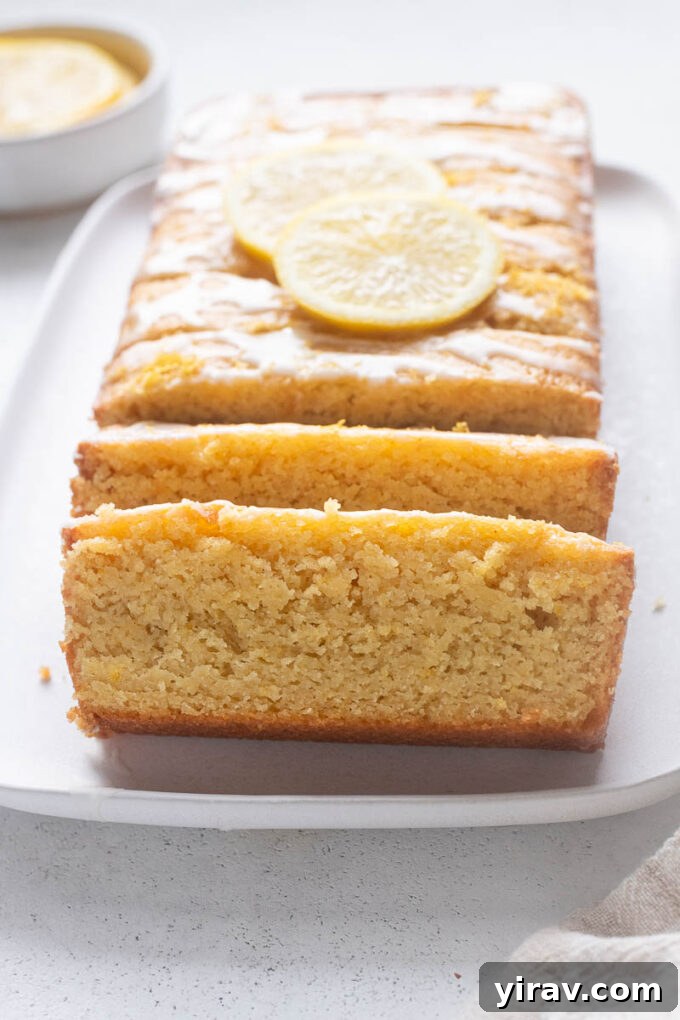 A meticulously sliced lemon loaf with almond flour presented on an elegant platter, ready for guests.