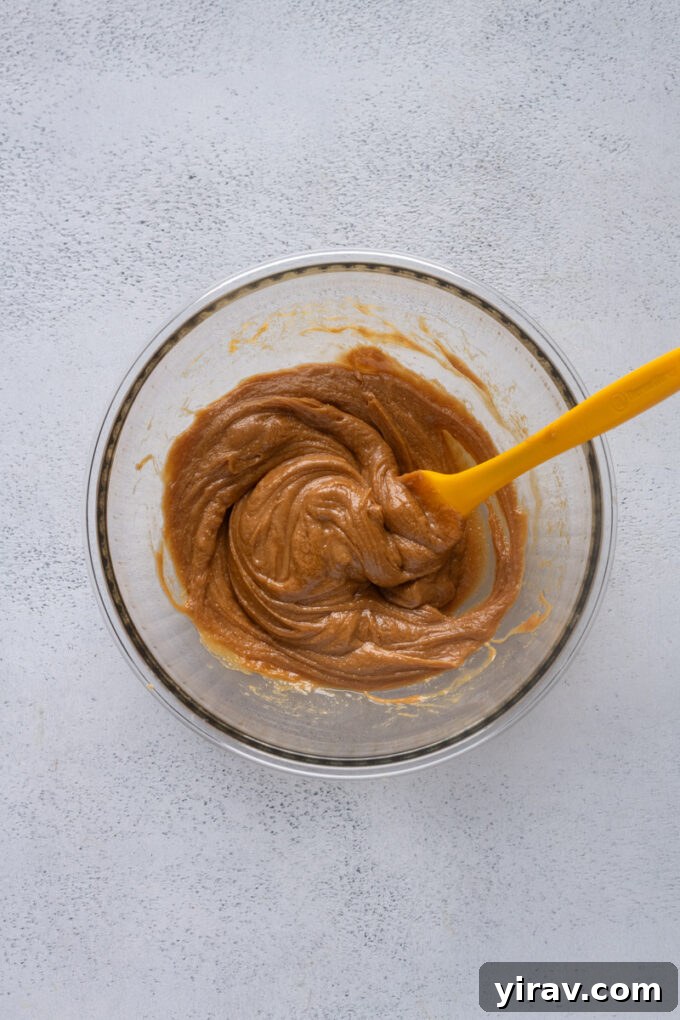 Wet ingredients for peanut butter protein balls being stirred in a bowl.