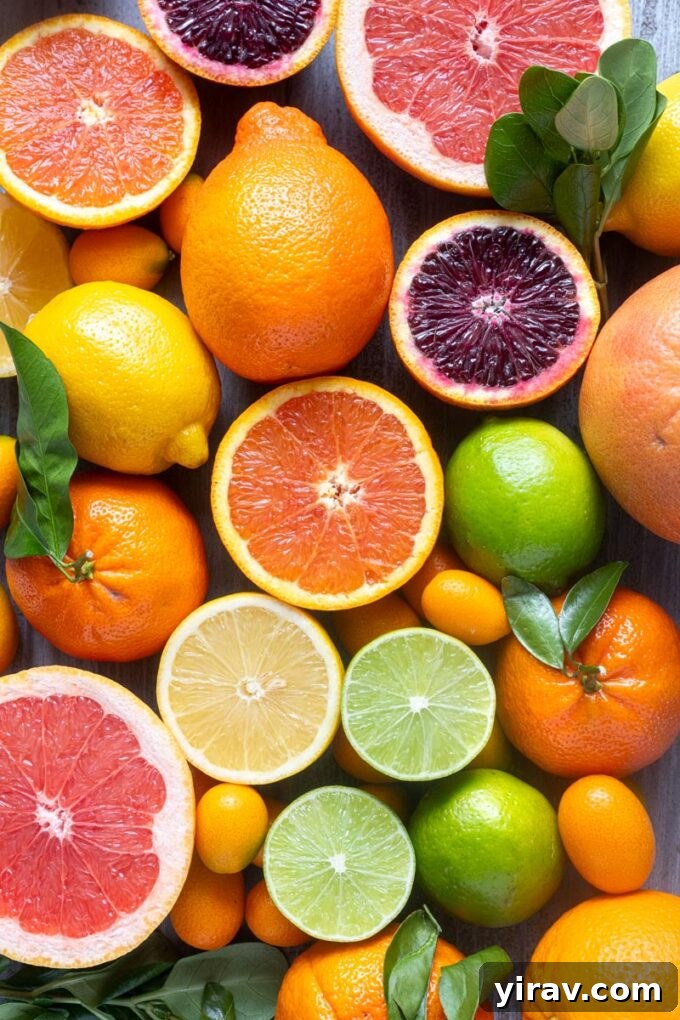 Assorted citrus fruits including oranges, lemons, limes and grapefruit arranged on a wooden surface.