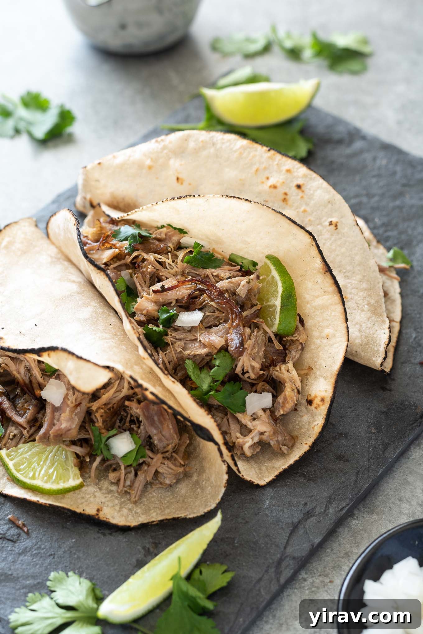 Slow Cooker Pork Carnitas in tortillas with onion, cilantro and lime