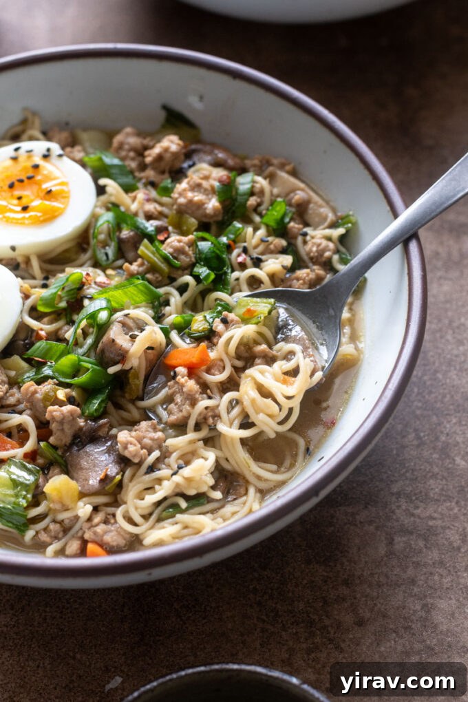 Bowl of Ground Pork Ramen with a spoon buried inside.
