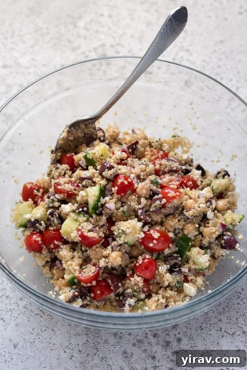 Greek quinoa salad in bowl with a spoon