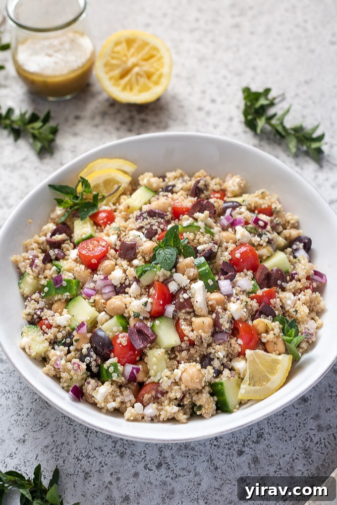 A close-up of Greek quinoa salad garnished with fresh lemon slices and dried oregano, highlighting the vibrant colors and textures.