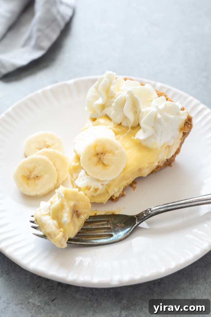 Slice of banana cream pie on a white plate