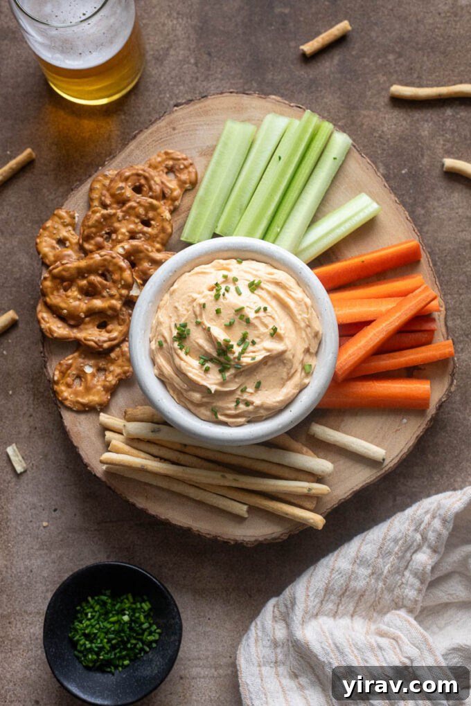 Artisan Cheddar Pub Spread 3 White cheddar pub cheese on a board with veggies and pretzels.