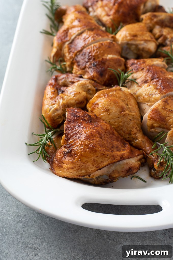Carved spatchcock chicken on platter with fresh rosemary garnish