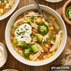 Crock Pot Green Enchilada Chicken Soup in a bowl with toppings.