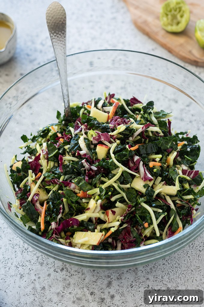 Kale slaw tossed with honey lime dressing in a glass bowl