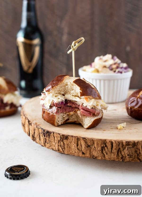 Deli-Style Corned Beef Bites 3 Guinness corned beef sliders on serving platter with a bite out of front slider