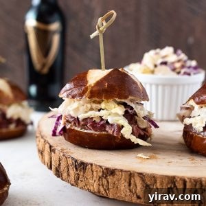 Guinness corned beef sliders with wooden pick through top.