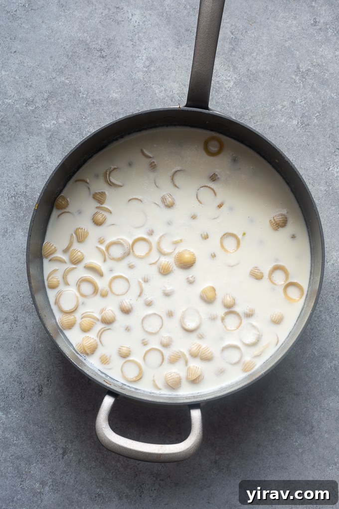 Effortless Spring Garden Pasta 6 Pasta in a skillet with water and cream.