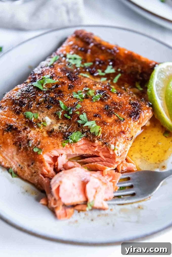 Blackened salmon on a plate with a fork flaking a corner