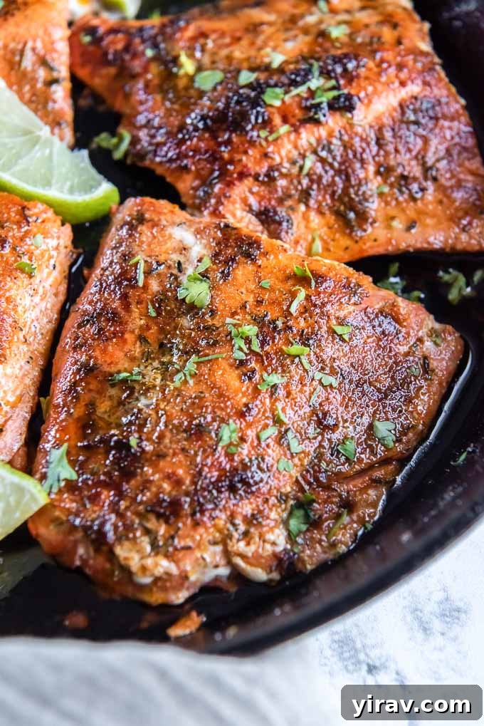 Blackened salmon in the skillet with parsley and lime