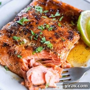 Blackened salmon on a plate with a fork flaking a corner