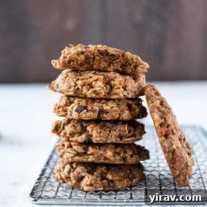 Golden Spiced Carrot Oat Cookies 10 Carrot oatmeal cookies stacked with a bite out of the top cookie.