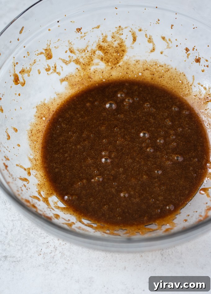 Golden Spiced Carrot Oat Cookies 4 Melted coconut oil and coconut sugar being beaten in a large bowl with an electric mixer.