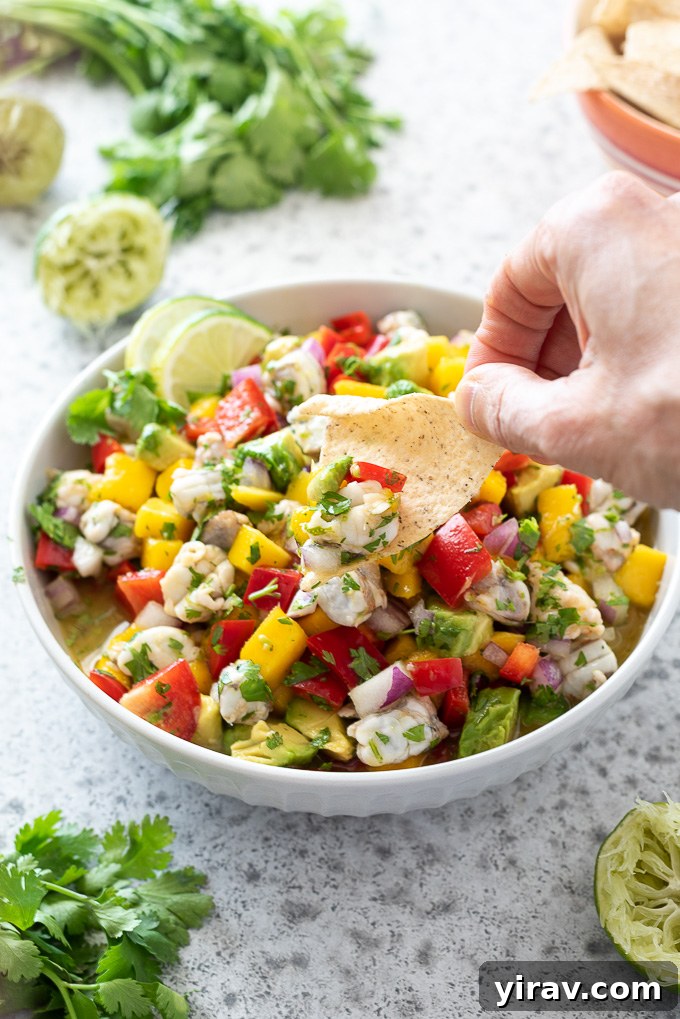 Effortless Shrimp Ceviche 6 Tortilla chip dipped into a bowl of shrimp ceviche